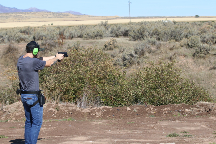 Man shooting gun in wilderness