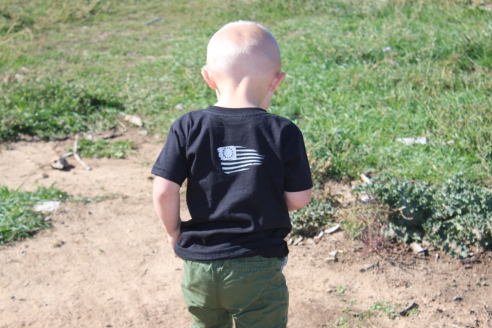 Toddler with Dominate Defense T-shirt, back view
